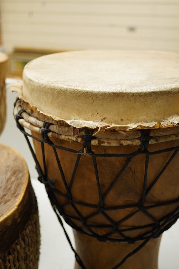 Five African drums; a Djembe, 50cm high, together with four others, including a pottery triple drum, etc. Condition - fair to good.